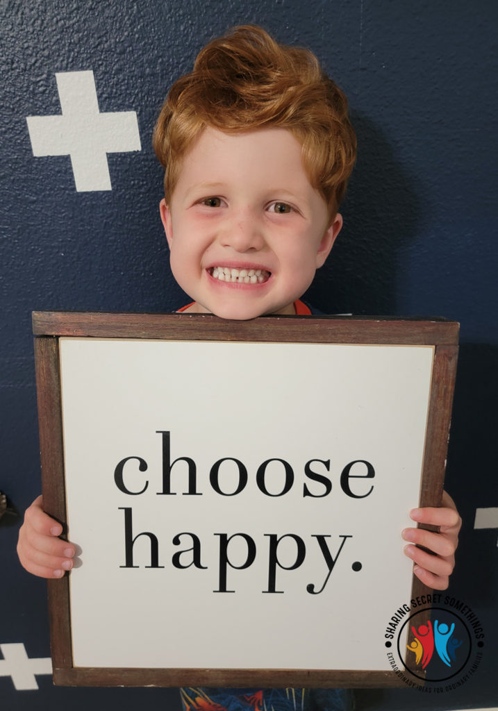 Cutest little redhead holding up a happy sign