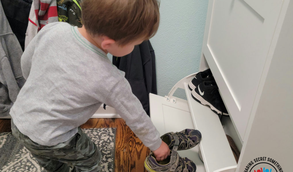 A Toddler learns to pick up and put away shoes